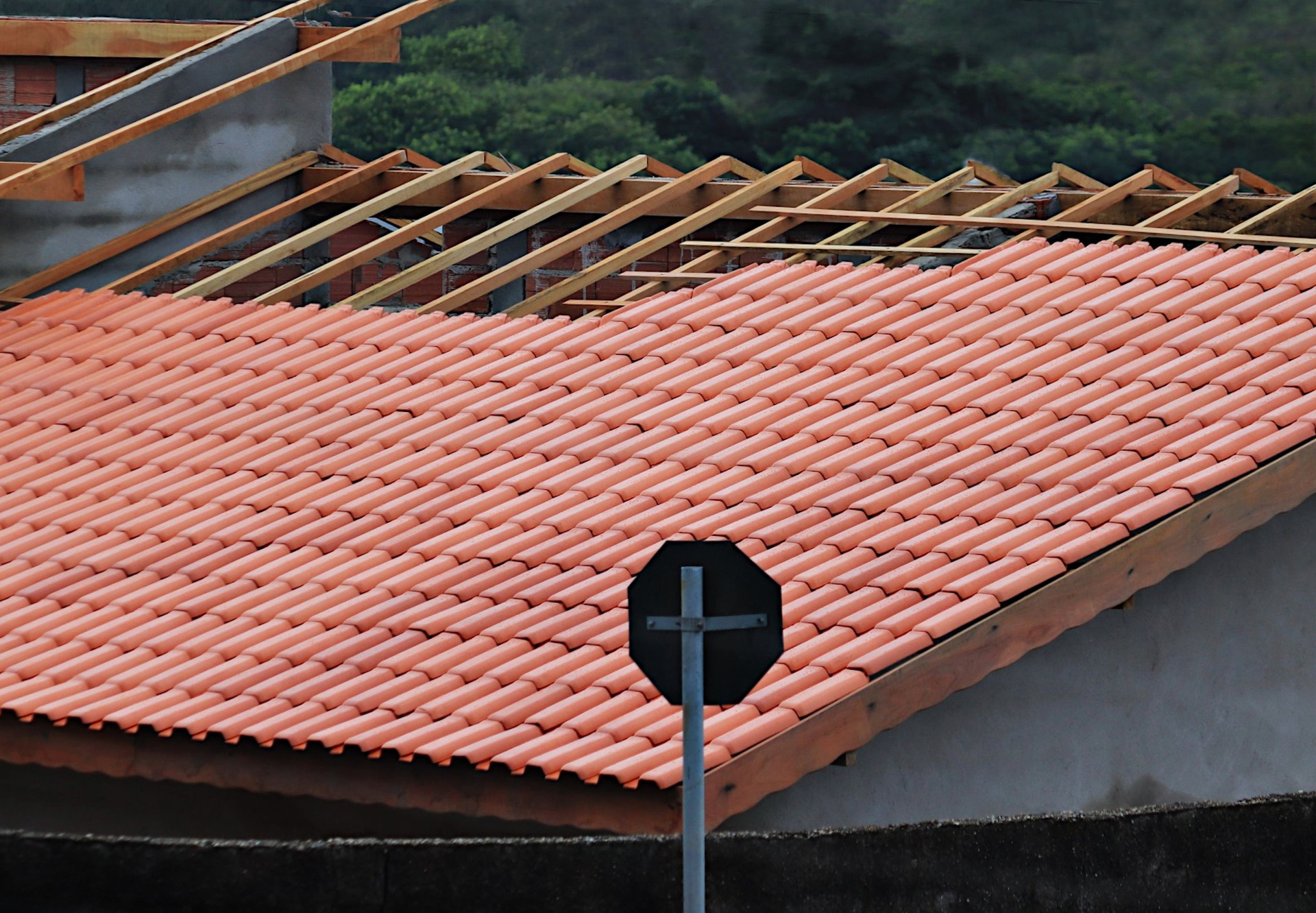 Moradia com telhado em construção, quase terminada, utilizando telhas romanas na sua construção.